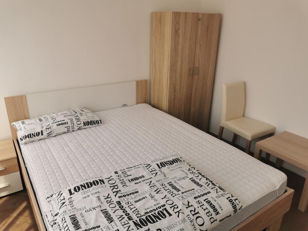 A bed with a quilted mattress and a headboard, a bedside table, and a bench.