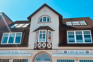 A building with a cafe named 'CAFÉ die insel' on the ground floor. - House with sea view - Apt. 3 (Wyk auf Föhr)