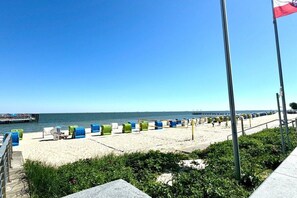 A beach with lounge chairs and a flagpole. - House with sea view - Apt. 3 (Wyk auf Föhr)