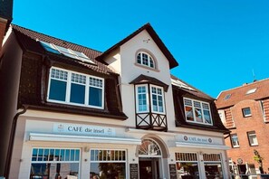 A building with a cafe named 'CAFÉ die insel' on the ground floor. - House with sea view - Apt. 2 (Wyk auf Föhr)