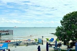 A waterfront view with a pier, a beach, and a restaurant named GEMANN. - House with sea view - Apt. 2 (Wyk auf Föhr)