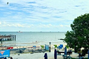 A waterfront promenade with a pier, seating areas, and a sign for 'AGEMANN'. - House with sea view - Apt. 4 (Wyk auf Föhr)