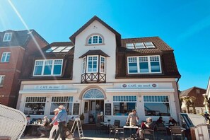 A café with a traditional architectural style, featuring a prominent bay window and a balcony. - House with sea view - Apt. 4 (Wyk auf Föhr)