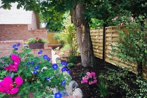 A garden with a brick wall, a wooden fence, and a tree. - 5 Martinique at the Boldix House (Wyk-Boldixum)