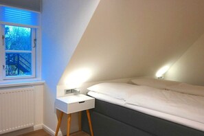 A bedroom with a bed, bedside tables, and a window with blinds. - 5 Martinique at the Boldix House (Wyk-Boldixum)