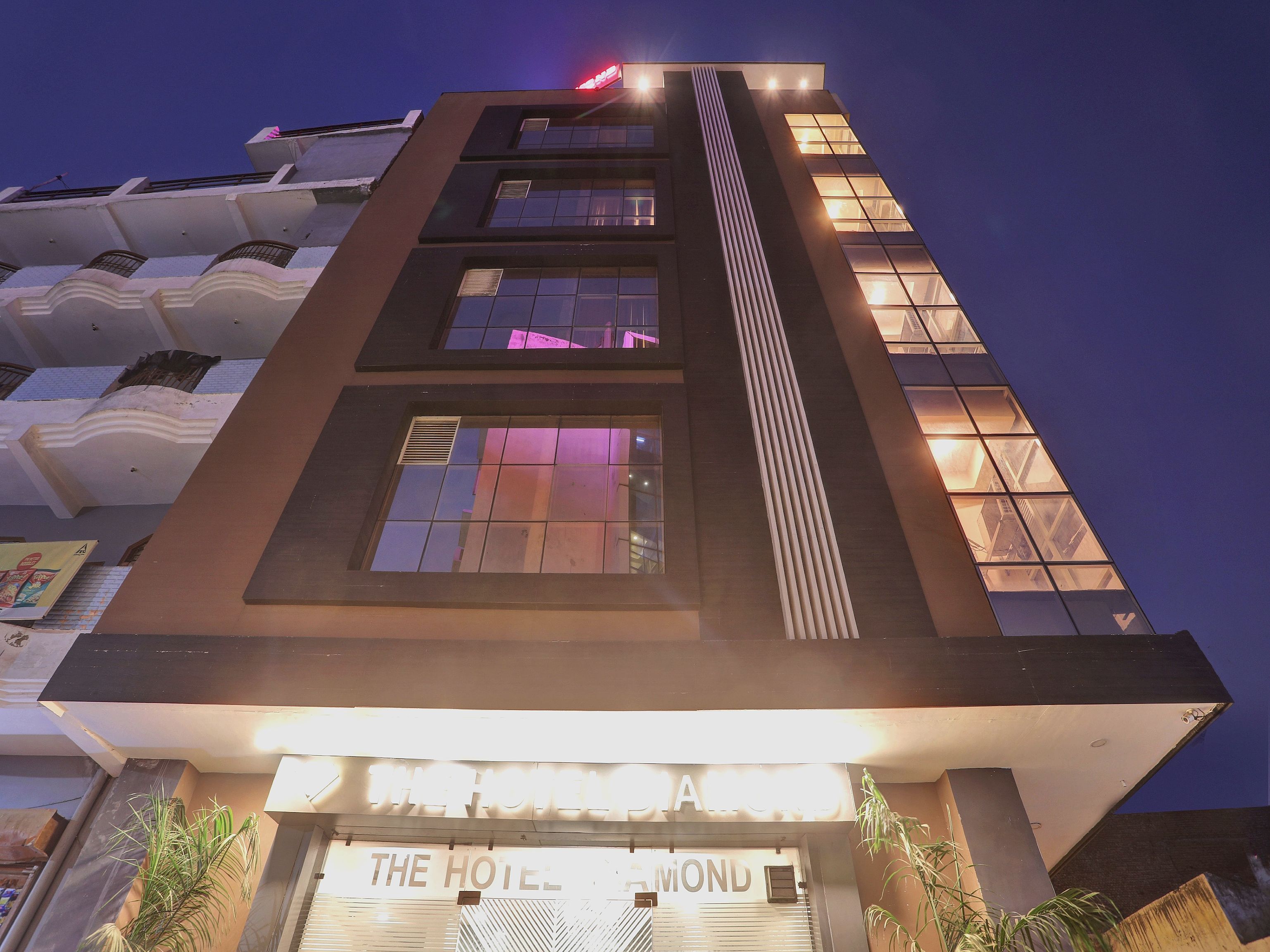 A hotel building with multiple floors, large windows, and a sign that reads 'THE HOTEL'.
