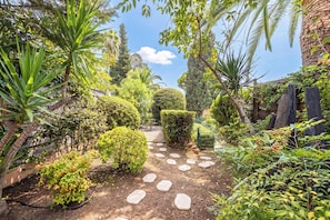 A garden pathway with stepping stones, surrounded by various plants and trees. - Family Apartment With Pool & Garden 5 P - Cannes (Cannes)