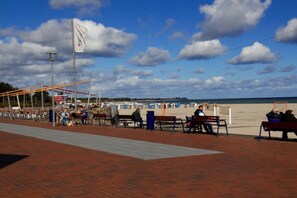 A beachside promenade with benches and a flagpole. - Holiday home in Damp with swimming pool (Damp)