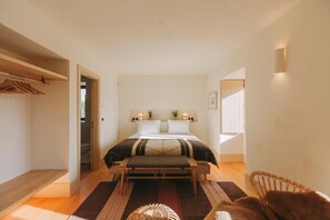 A bedroom with a bed, bedside tables, a bench, a chair, and a small rug. - Taboadella Casa Villae Relais & Chateaux (Silvã de Cima)