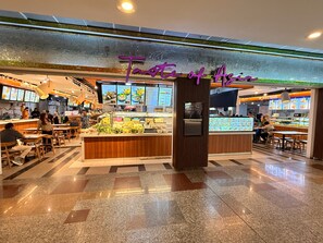 Una sala de comidas con varias zonas de estar y mostradores de comida.