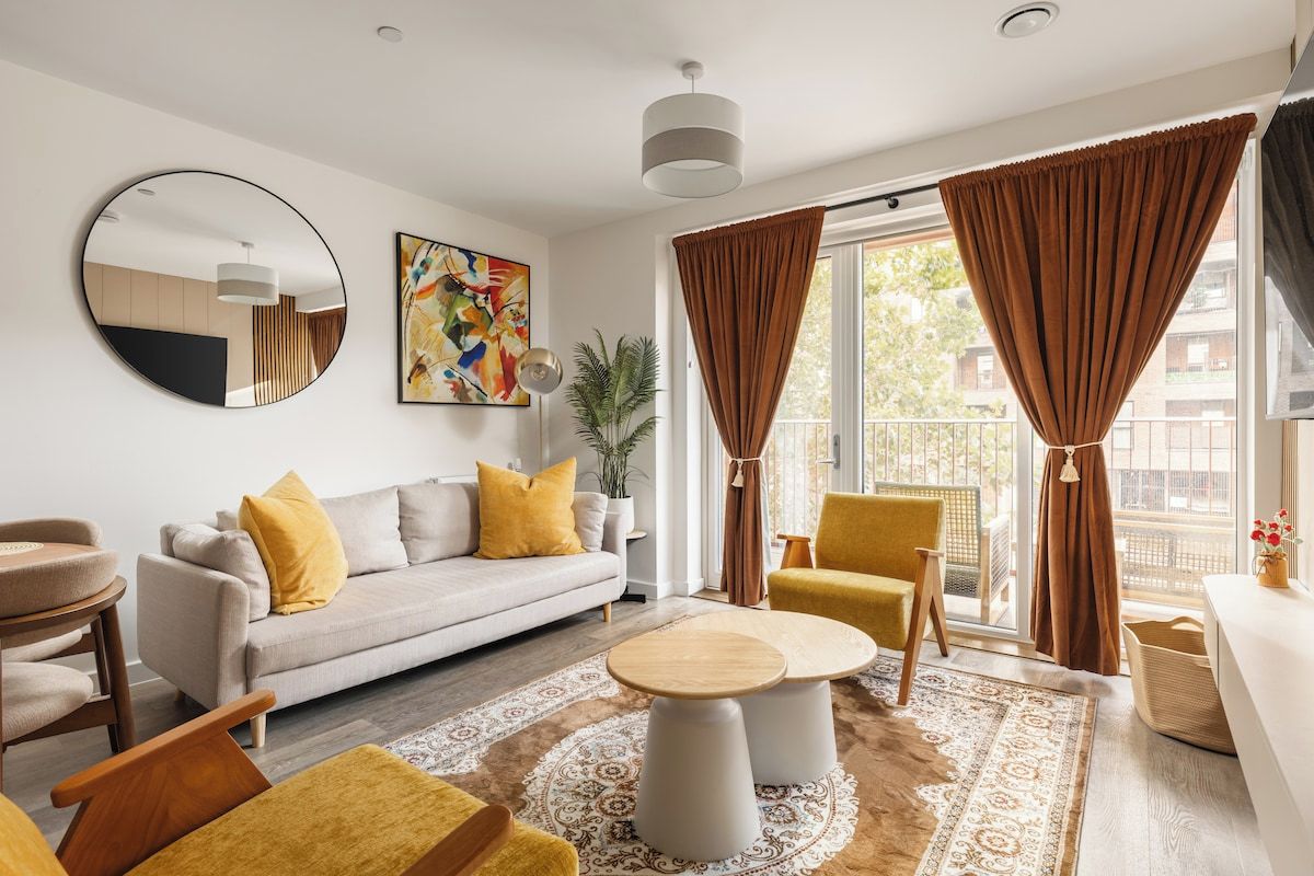 A modern living room with a sofa, armchairs, a coffee table, and a large window with curtains.