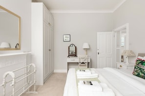A bedroom with a bed, a desk, a chair, a wardrobe, and a mirror. - Peaceful 2BR Fulham Maisonette | Private Terrace (Greater London)