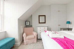 A bedroom with a bed, a chair, a dresser, a wardrobe, and a lamp. - Peaceful 2BR Fulham Maisonette | Private Terrace (Greater London)