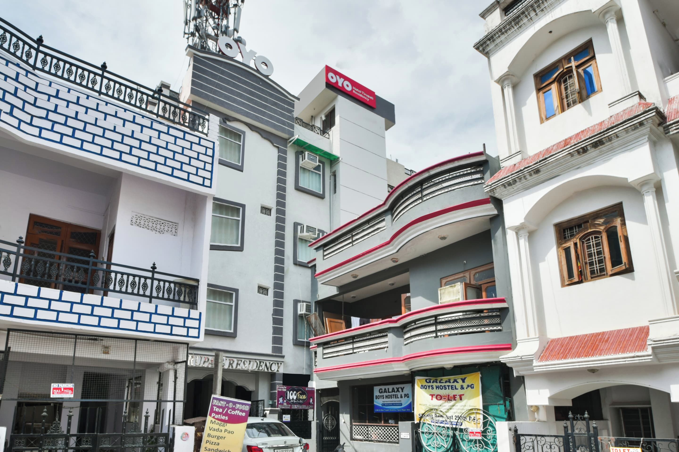 Un edificio de varios pisos con diversos comercios en la planta baja, incluyendo un restaurante y un albergue.