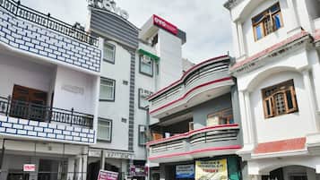 Un edificio de varios pisos con diversos comercios en la planta baja, incluyendo un restaurante y un albergue.