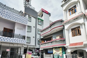 Un edificio de varios pisos con diversos comercios en la planta baja, incluyendo un restaurante y un albergue.