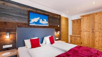 Una camera da letto con un letto, una testiera in legno, un quadro raffigurante una montagna e un armadio.