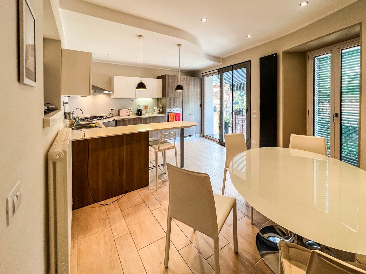 Une cuisine moderne avec un îlot central, une table à manger et des chaises.
