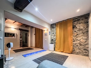 Un intérieur moderne avec un mur en pierre, un plafond blanc et un rideau marron.