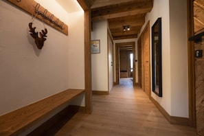 A hallway with wooden flooring, a bench, and a deer head decoration. - Tanikel - New 100-square-meter duplex | Quiet | Mountain view | Garden (Chamonix-Mont-Blanc)