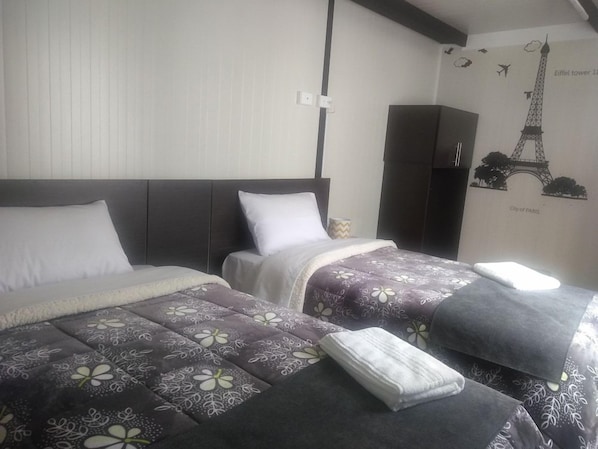 A hotel room with two beds, a wardrobe, and a wall with a Paris-themed mural. - Hotel & Golf Isak (Rionegro)