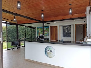 A reception area with a wooden ceiling, a reception desk, and a logo for Isak Hotel. - Hotel & Golf Isak (Rionegro)