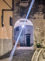 Un arco de entrada a un edificio con un pequeño porche y una banca.
