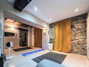 Et moderne interiør med en stenvæg, en blå oplyst sti og et siddeområde med en hvid sofa.