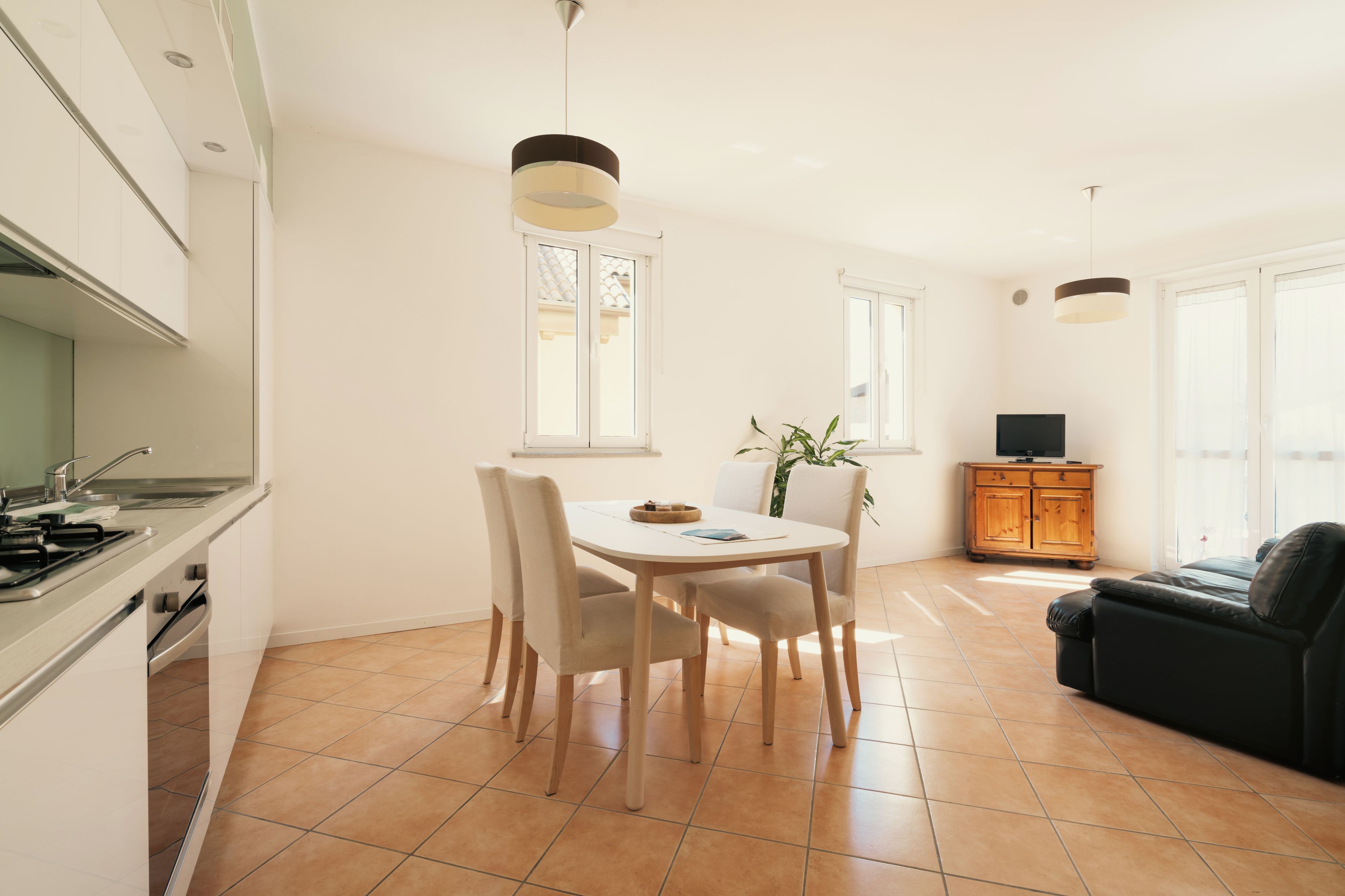 Una cucina moderna con zona pranzo, divano e televisore.