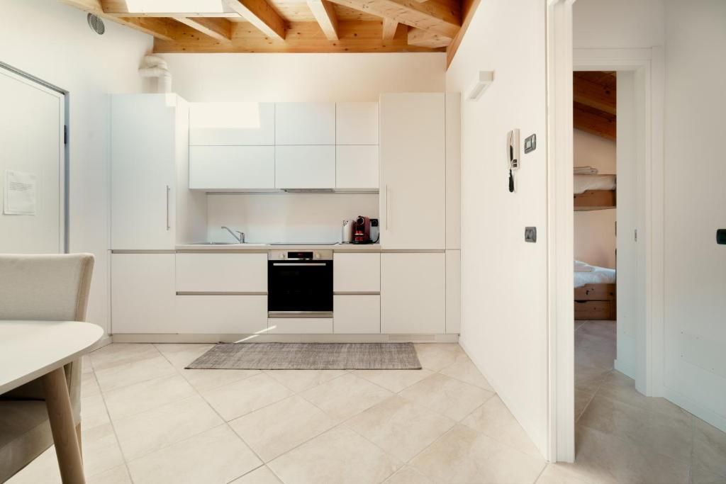 Een compacte keuken met witte kastjes, een ingebouwde oven en een klein aanrecht.