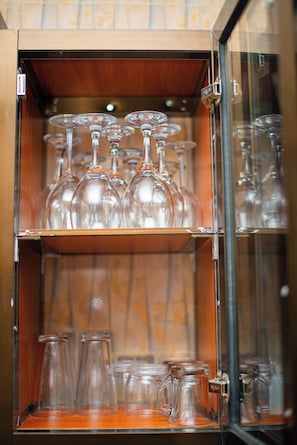 Un expositor de vidrio con diversos vasos, incluyendo copas de vino y vasos sencillos.