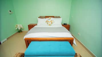 Un dormitorio con una cama, una mesita de noche y un banco azul.