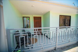A balcony with a metal railing, a door, and a window.