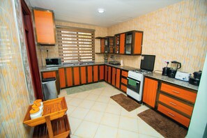A compact kitchen with wooden cabinets, a stove, and a microwave.
