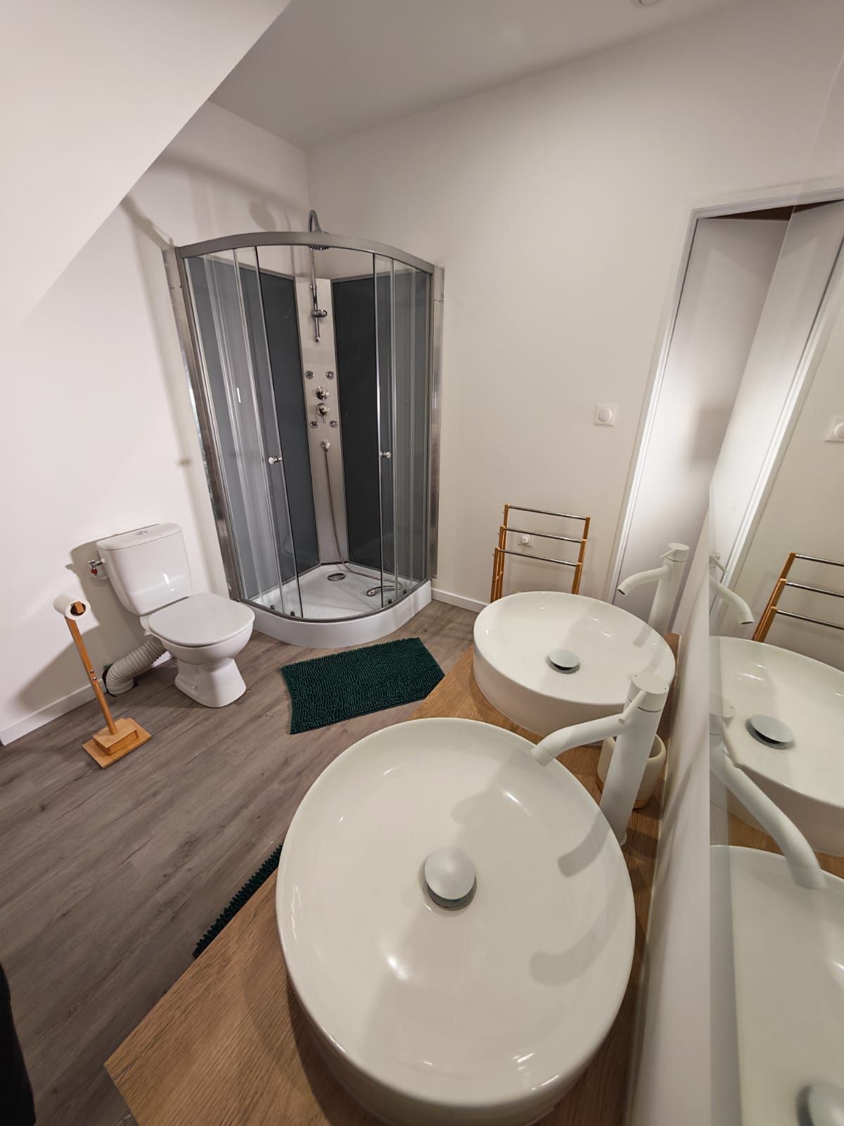 Ein modernes Badezimmer mit Dusche, Toilette und zwei Waschbecken.
