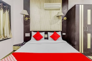 A hotel room with a bed, a wardrobe, an air conditioning unit, and a telephone. - Hotel O Vintage House (Agra)