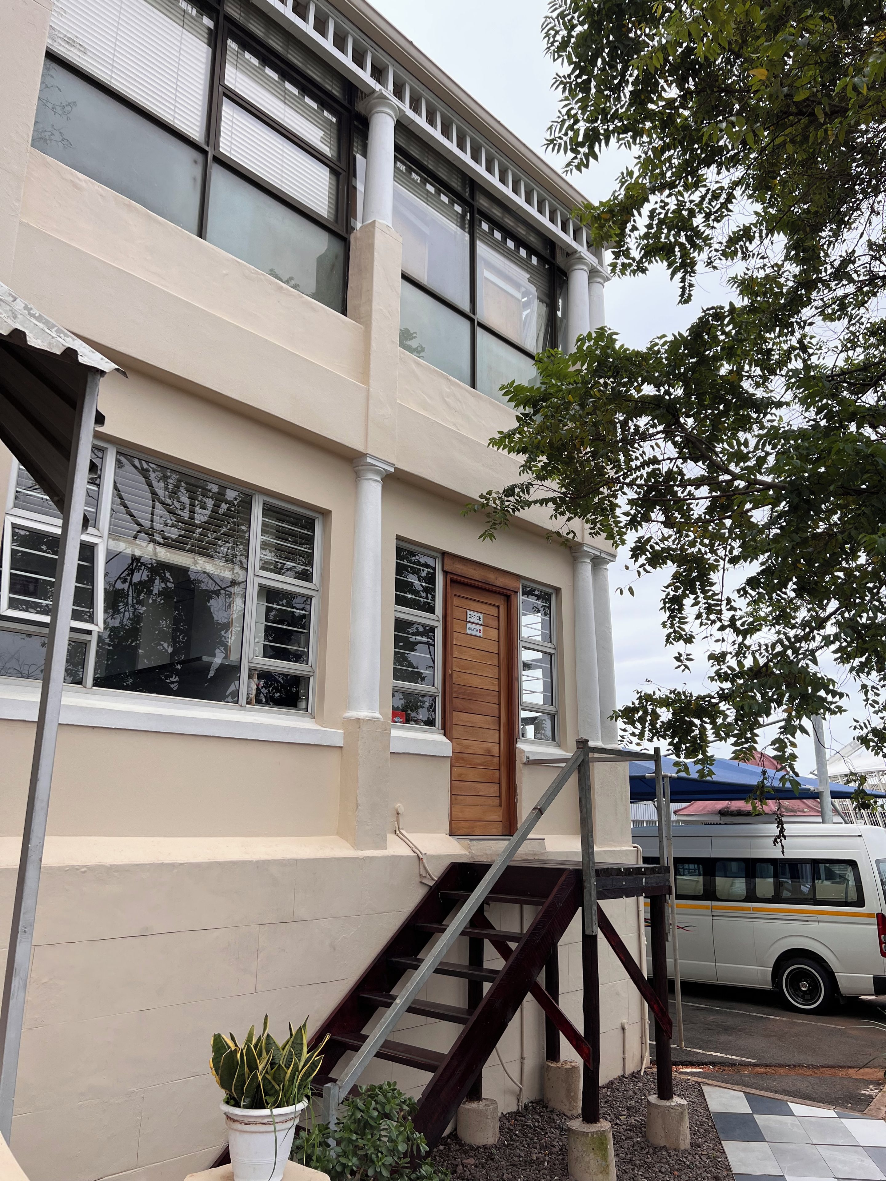 Un edificio con una escalera que lleva a una puerta con la etiqueta 'Office'.
