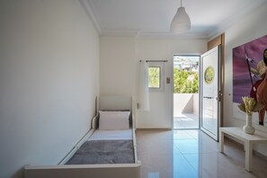 Quarto com cama, mesa de cabeceira, janela e vista exterior.