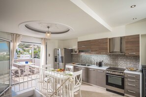 Cozinha moderna com forno embutido, eletrodomésticos de aço inoxidável e vista para o exterior.