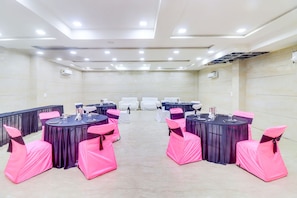 Un salón de conferencias con mesas redondas, sillas e iluminación en el techo.