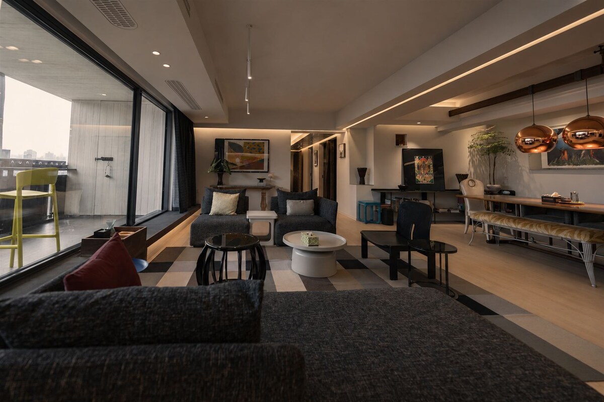 A modern living room with a sofa, coffee table, and dining area.