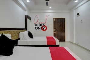 Habitación de hotel con cama, una pared con una cita motivacional, una puerta y un ventilador de techo.