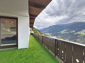 A balcony with artificial grass, a wooden railing, and a view of a mountainous landscape. - Wonderful private villa for 6 people with WIFI, TV and terrace (Urgen)