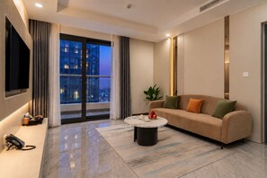 Ein modernes Wohnzimmer mit einer Couch, einem Couchtisch, einem Fernseher und Blick auf die Stadt.