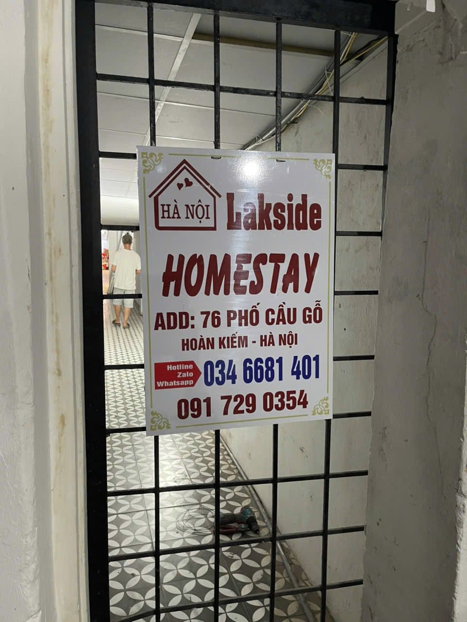 A sign for a homestay named 'HA NOI Lakside' with contact information and address.