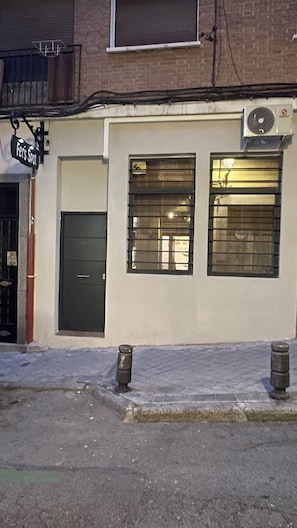 A building with a closed door, a window with blinds, and a sign above the door. - FER’s SPOT beautiful studio/apartment downtown Madrid close to all imprtnt spots (Madrid)