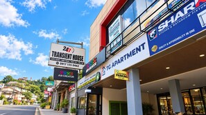Un edificio comercial con varios letreros, incluyendo una casa temporal, creador de aire y estacionamiento para clientes.