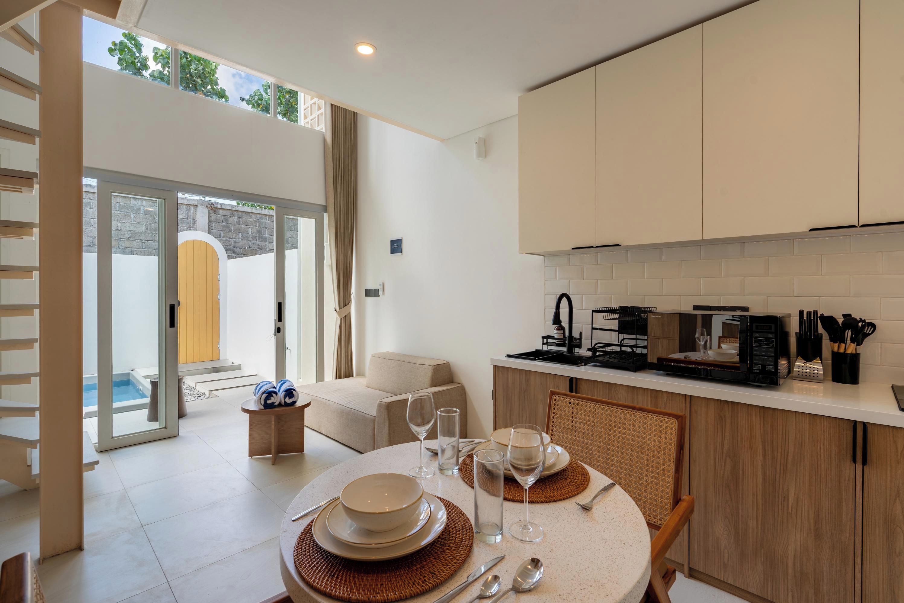 Une cuisine moderne avec un coin repas, un four encastré et une vue sur une piscine.