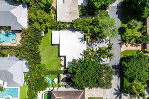 A residential area with a swimming pool, a patio, and lush greenery. - Charming Delray Beach Home in Lake Ida (Delray Beach)