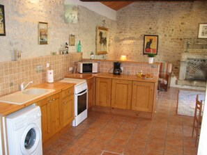 A kitchen with wooden cabinets, a washing machine, a microwave, and a coffee maker. - Holiday Home 'Limerac, Cottage' with Shared Pool, Shared Terrace and Wi-Fi (Salles-Lavalette)